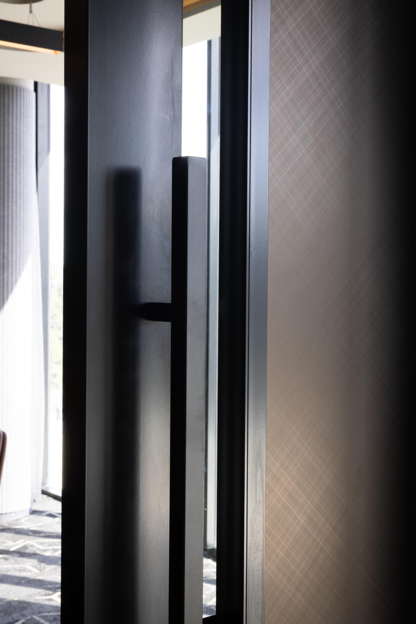 Leithal Designs' entry to executive boardroom at Infinity Group Australia, featuring sliding doors with Baresque vinyl finish and powdercoated full-length handles for a refined corporate aesthetic.