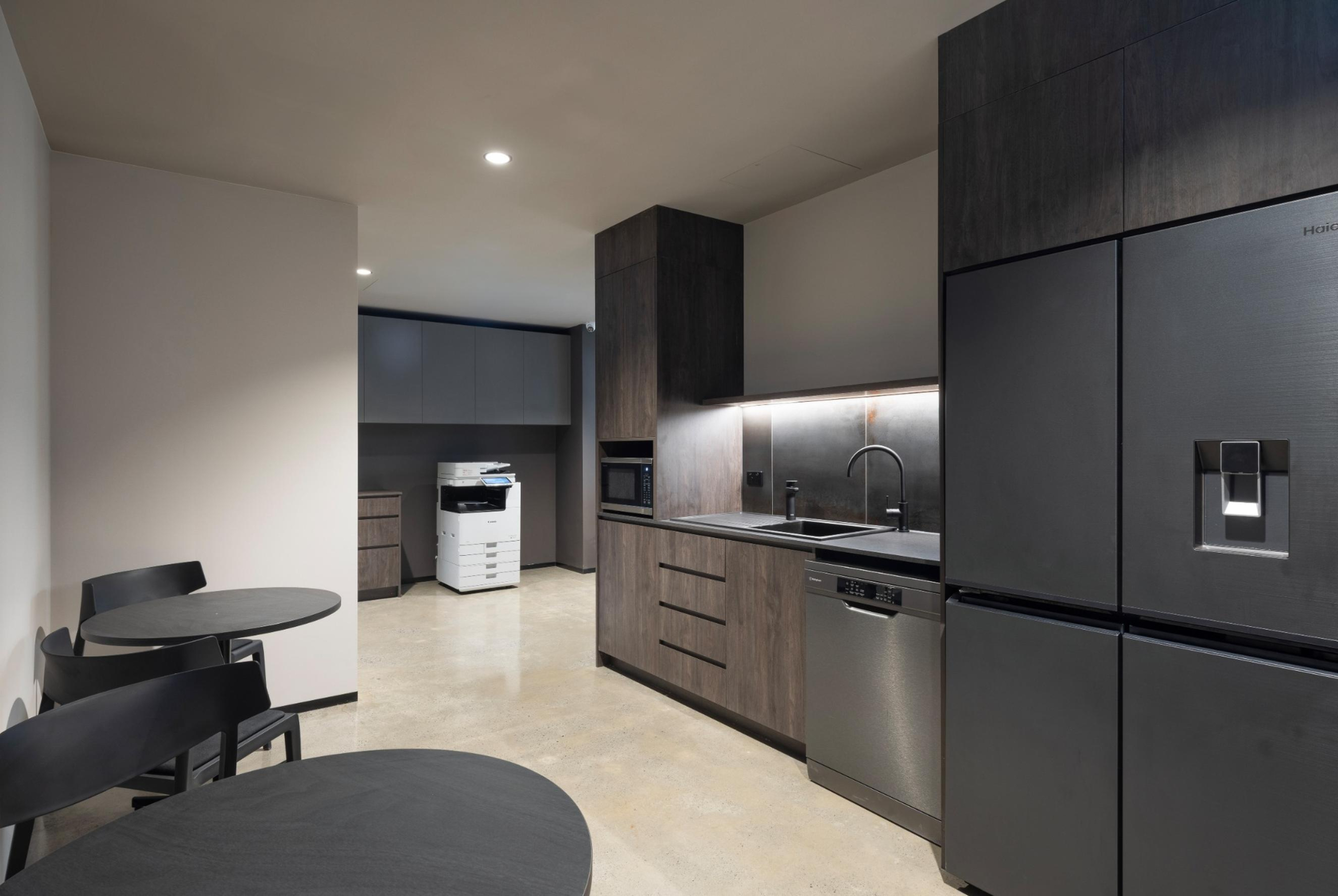 Leithal Designs’ executive kitchenette at Infinity Group Australia, showcasing Polytec laminate joinery and concealed utility access within a refined, corporate fitout in Southport.