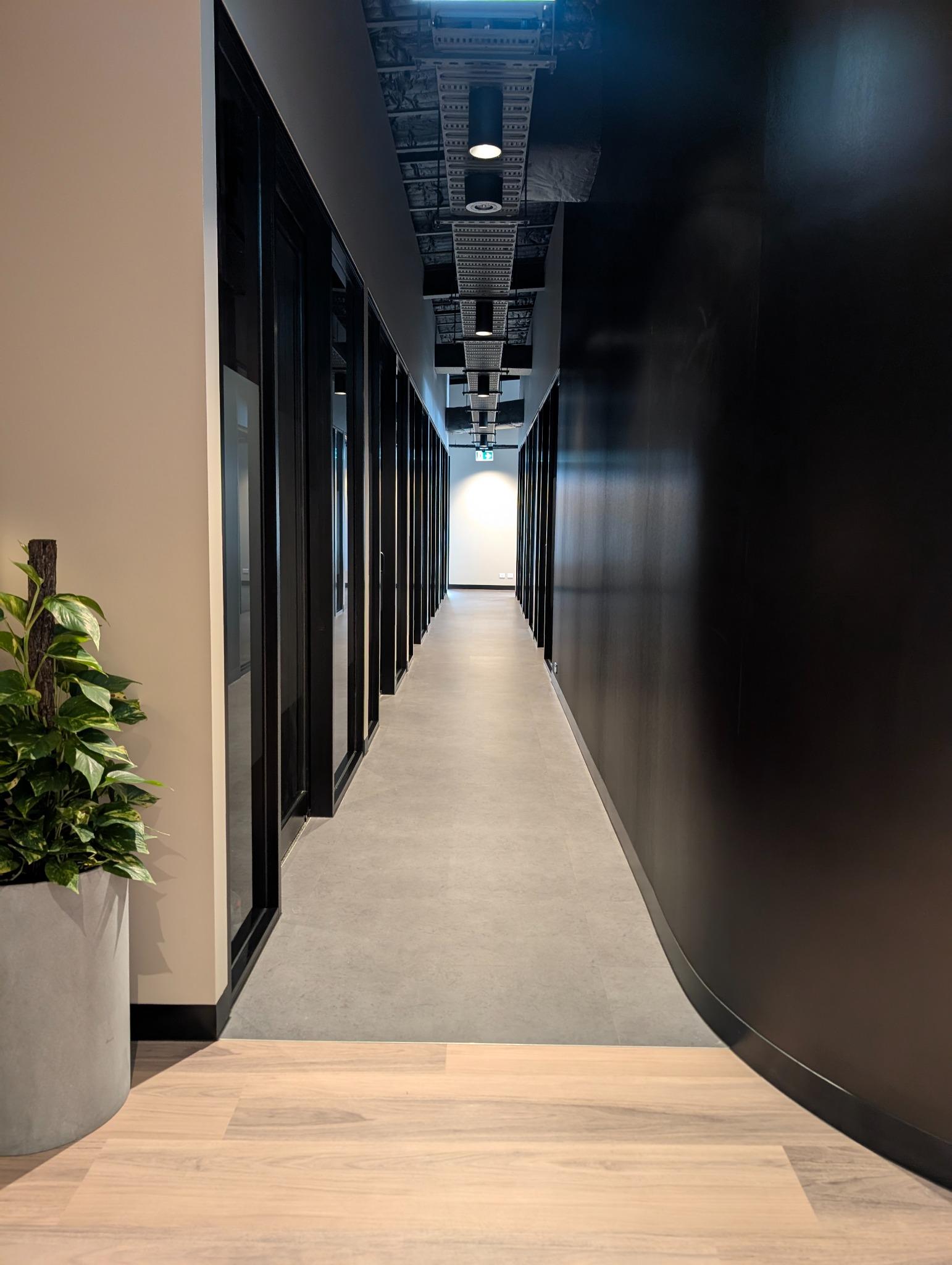Architectural hallway with curved black wall and exposed ceiling – interior architecture Gold Coast