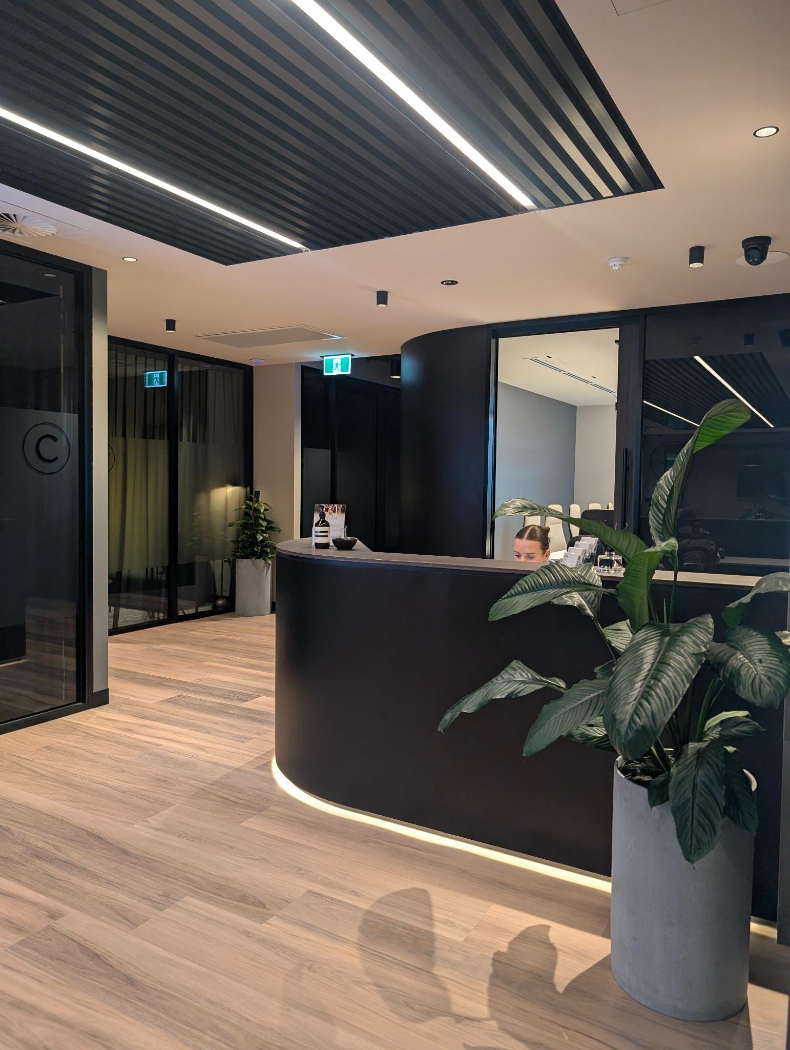 Reception area at Riva Offices Robina – corporate office fitout with curved joinery and warm timber finishes