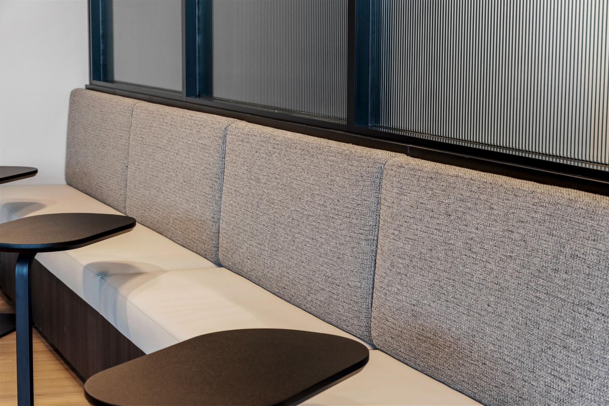 Close-up of textured bench seating and reeded glass partition – modern commercial fitout Gold Coast
