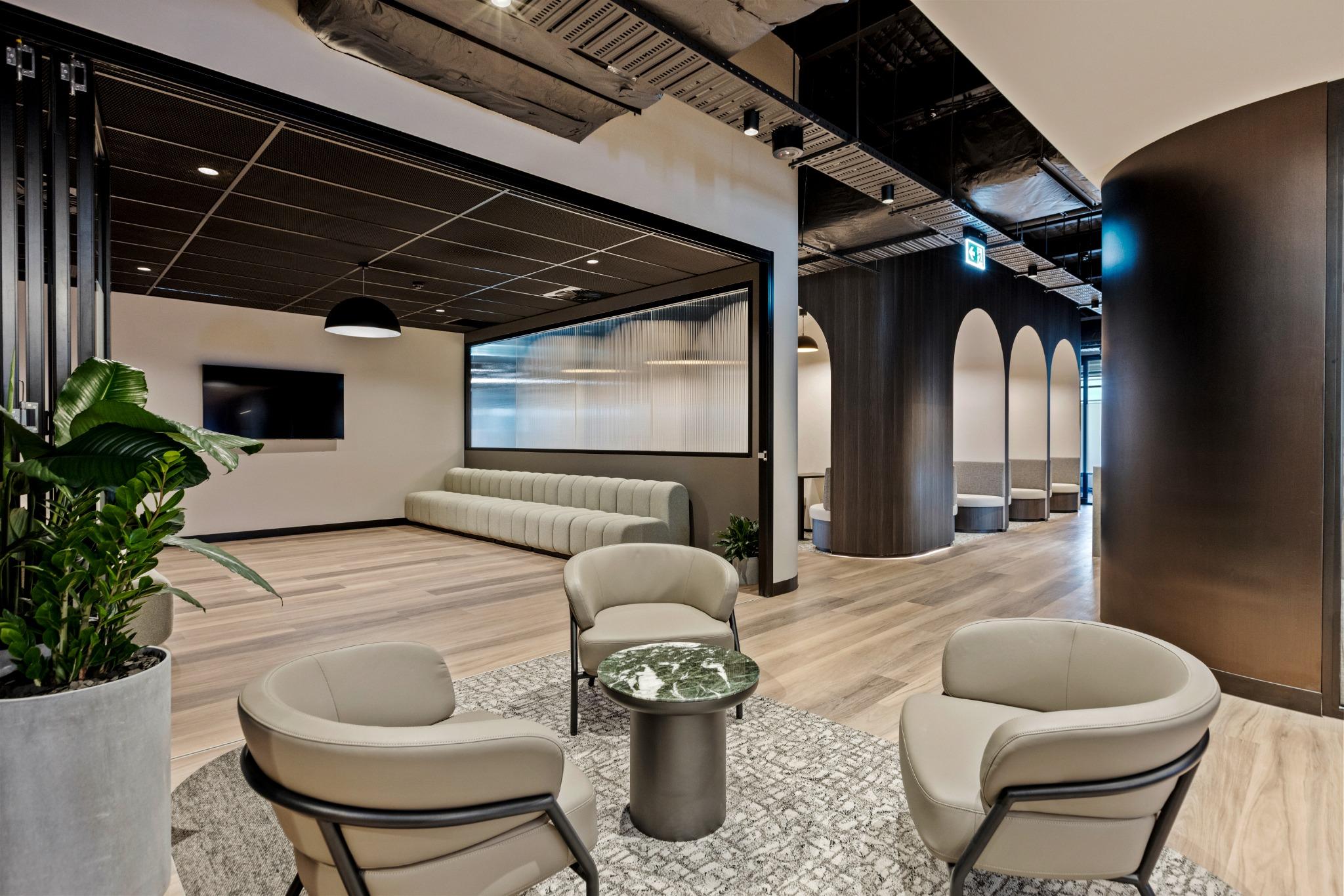 Glass corridor with symmetrical glazing and visible ceiling services for an industrial office fitout aesthetic.