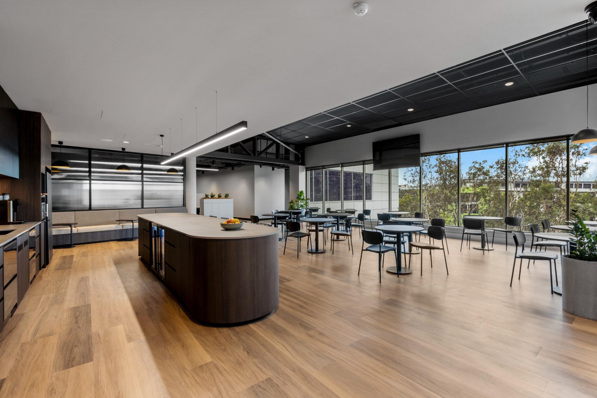 Flexible coworking breakout zone with custom joinery and full-height windows – interior fitout Gold Coast