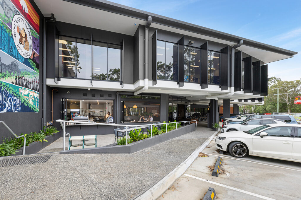 Crafty Monk Brewing exterior with modern design, large glass windows, outdoor seating, vibrant mural, and landscaping, illustrating luxury retail and hospitality fitout concepts.