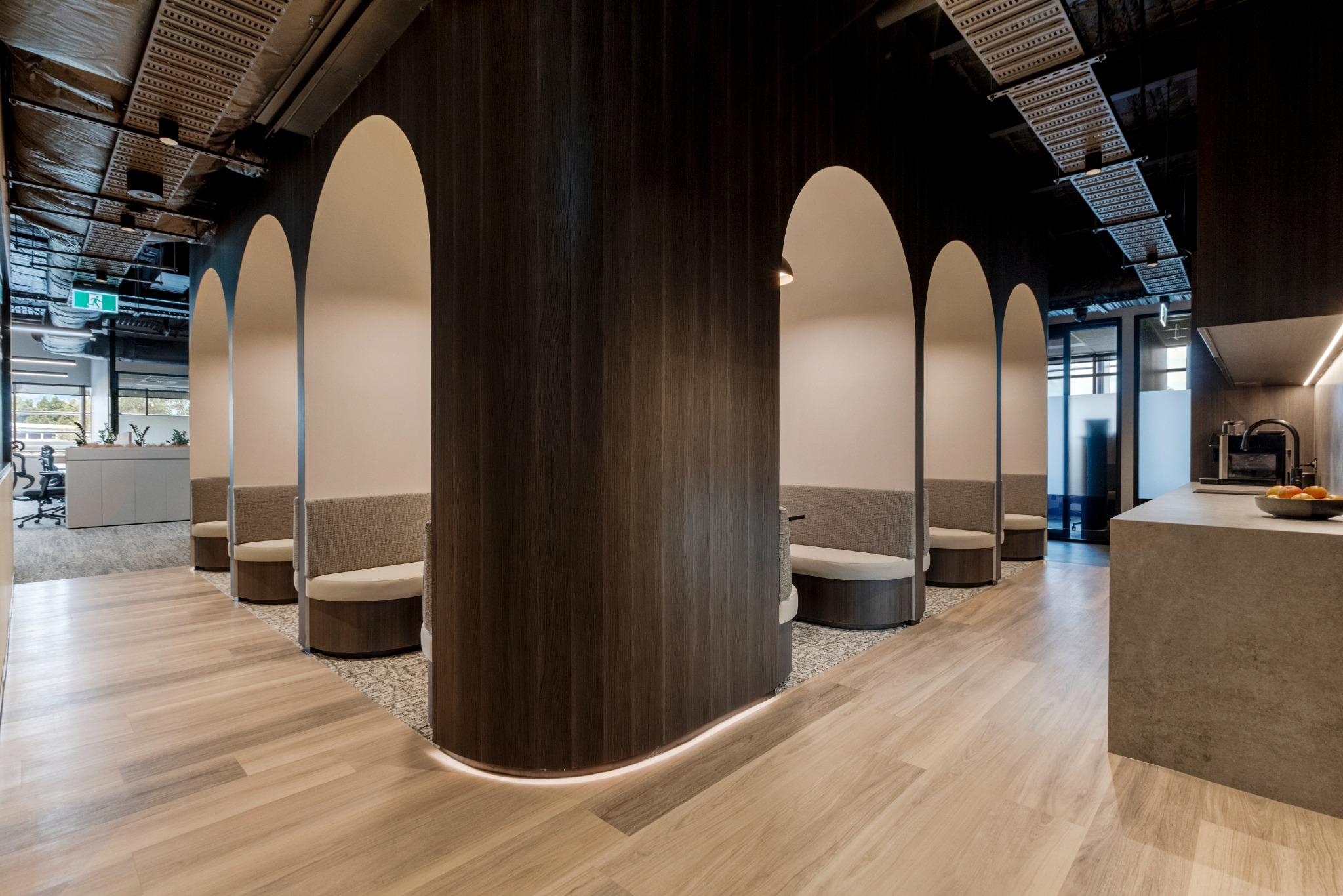Interior design of Proud Smile Dental Clinic featuring elegant seating areas with arched partitions, warm lighting, and a modern aesthetic, emphasizing a wellness-driven environment.